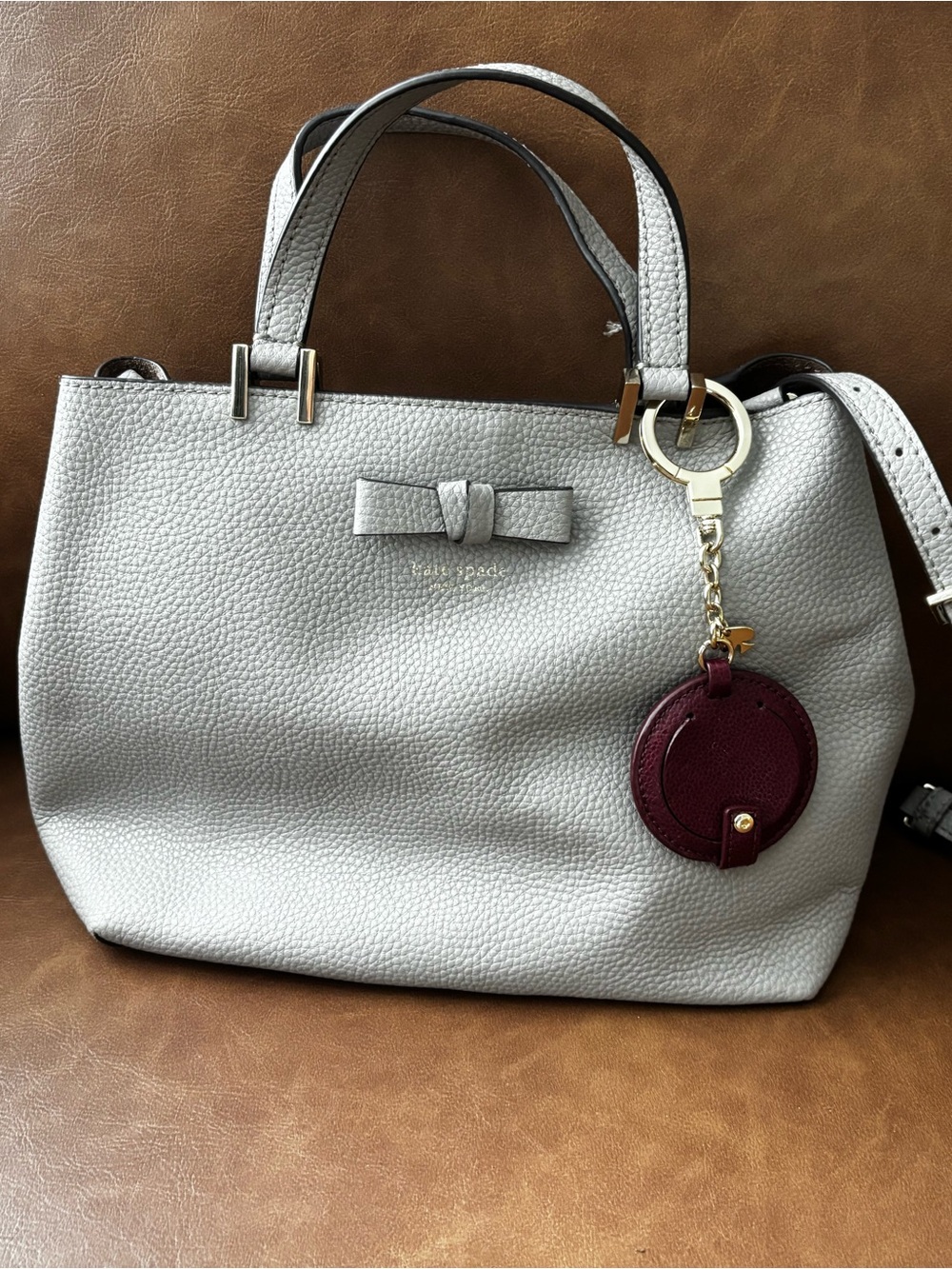 kate spade light gray pebbled leather satchel with burgundy charm